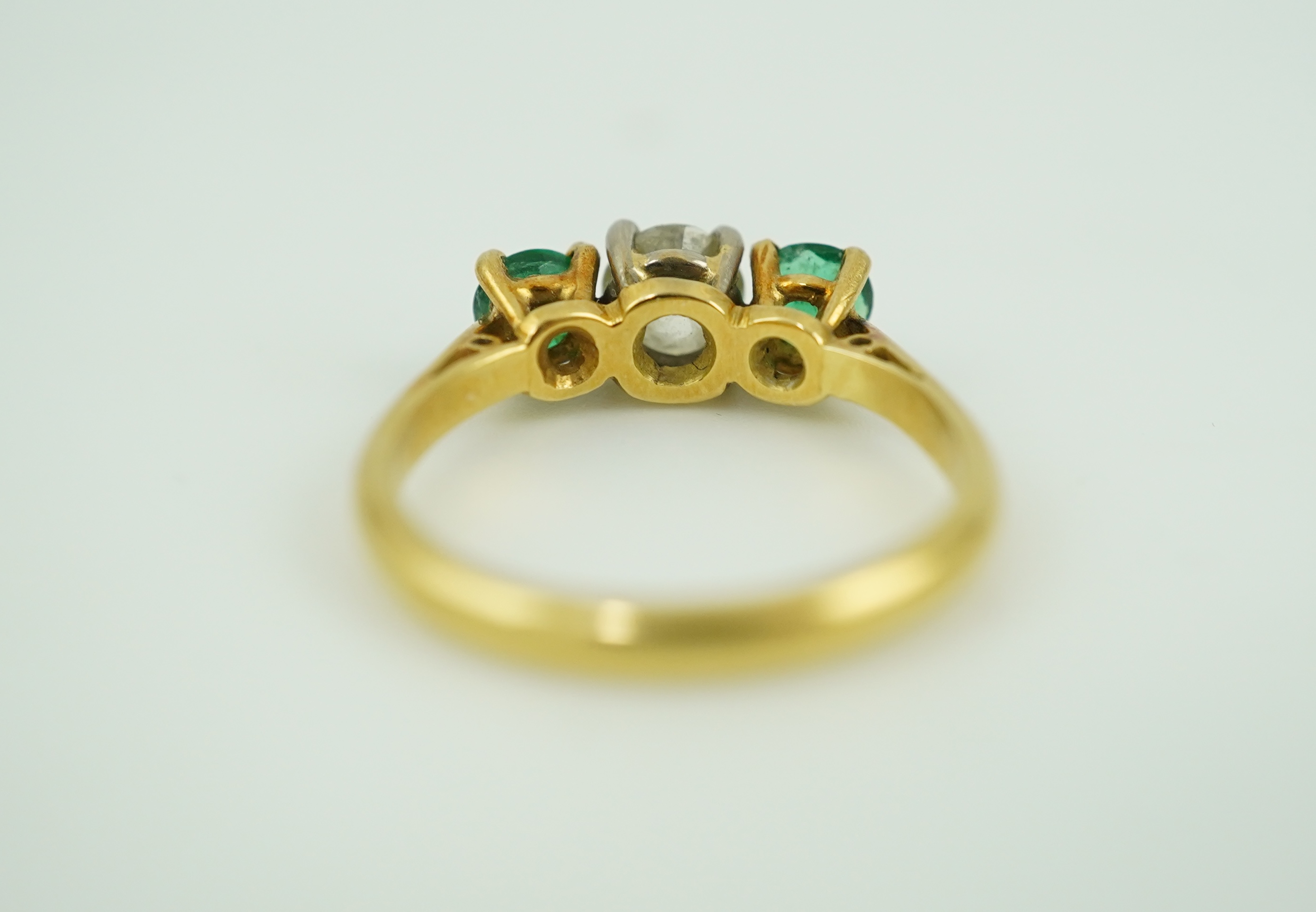 An emerald and diamond three-stone ring